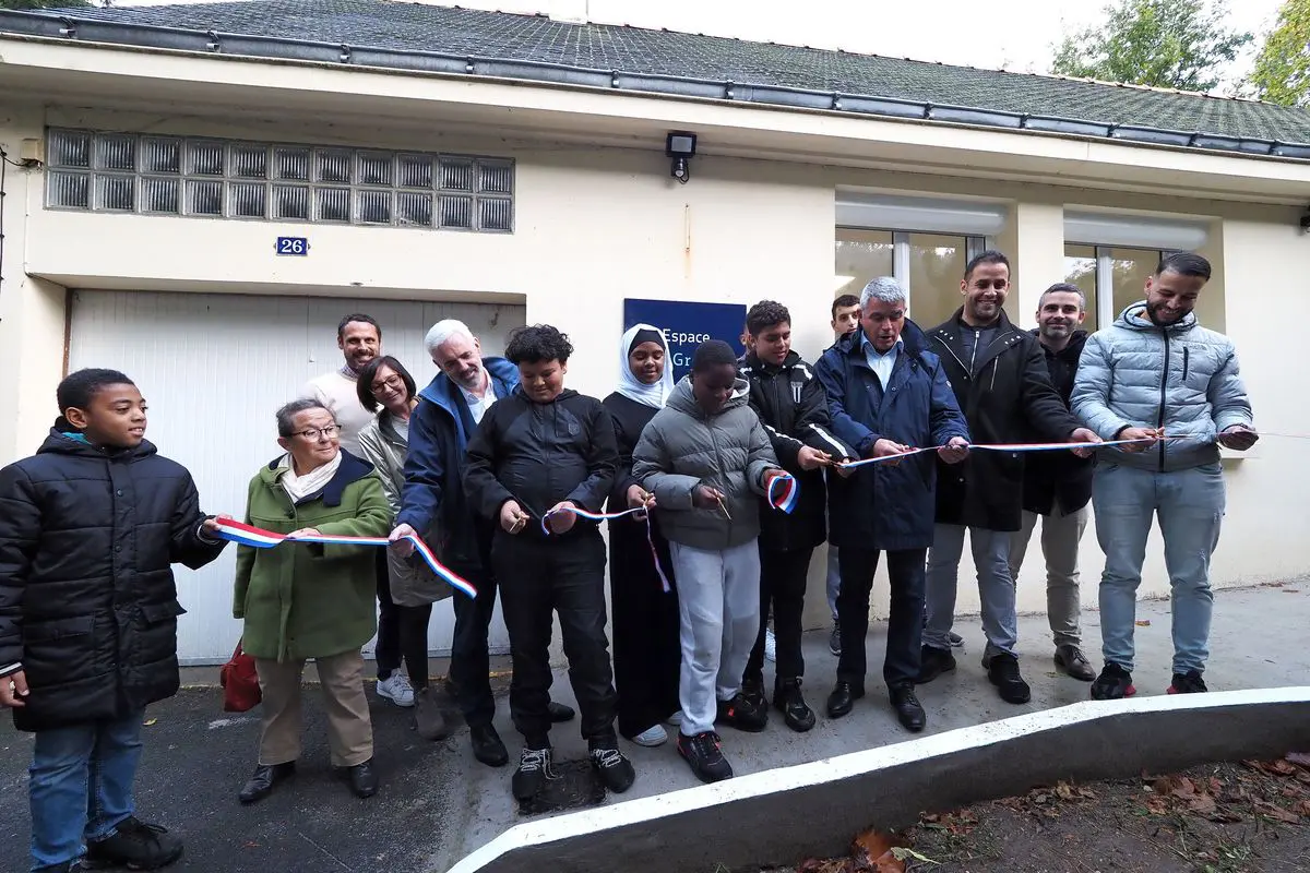 Inauguration des nouveaux locaux de l'AJN, 26 rue Pitre Grenapin : les enfants, les bénévoles et les élus coupent ensemble le ruban tricolore.